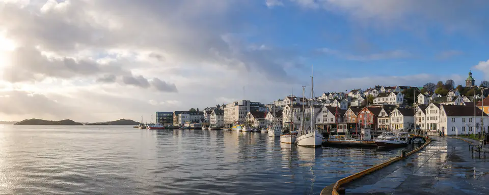 Illustrated view of Stavanger's sheltered harbor with small boats and white wooden houses after rain