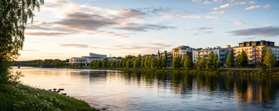 Illustrerad vy över Umeås älvstrand med moderna bostadshus, kulturbyggnad, träd och speglingar i kvällsljus